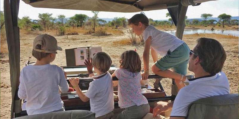 Children learning about wildlife during a family safari in Tanzania
